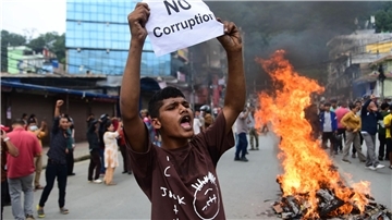 Ein Demonstrant in Nepal hält ein Blatt mit der Forderung nach einem Ende der Korruption hoch. 