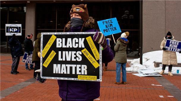 Adidas rudert im Streit mit Black Lives Matter zurück Ein Demonstrant mit einem „Black Lives Matter“-Schild in Minneapolis.