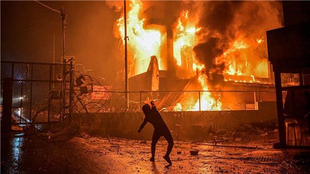 Wut in Nahost über Explosion bei Gaza-Klinik Ein Demonstrant wirft nach dem Angriff auf das Krankenhaus im Gazastreifen Steine auf ein brennendes Gebäude in der Nähe der US-Botschaft in Beirut.