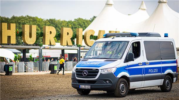 Ein Einsatzfahrzeug der Polizei fährt vor dem Gelände des Hurricane Festivals entlang.