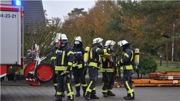 Ein erster Atemschutztrupp bereitet sich auf den schwierigen Einsatz am Hackschnitzel-Silo in Sandbostel vor.
