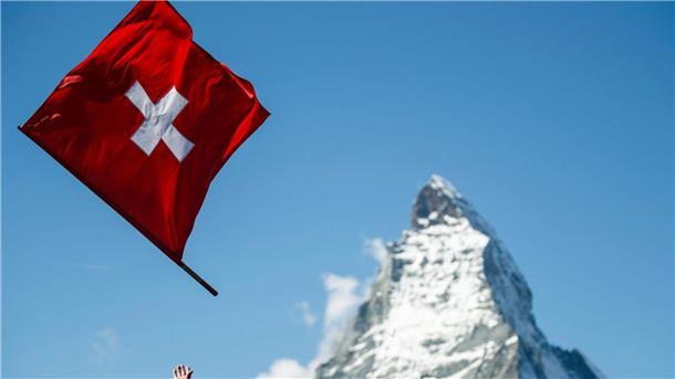 Das Image der Schweiz bröckelt Ein Fahnenwerfer mit der Schweizer Flagge in Aktion vor der Kulisse des Matterhorns.