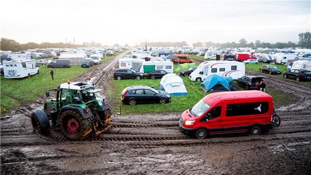 Nach Einlassstopp beim Wacken: Viele Fans müssen verärgert die Heimreise antreten Ein Fahrzeug wird mit Hilfe eines Traktors auf das Gelände des Heavy-Metal-Festivals in Wacken durch den Schlamm gezogen. Das WOA gilt als größtes Heavy-Metal-Festival der Welt.