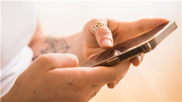 Hände halten ein Smartphone.