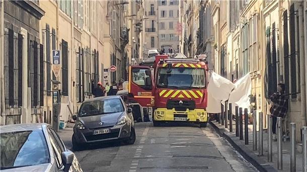 Ein Feuerwehrauto steht in einer Straße in der Nähe der Stelle, an der das Gebäude eingestürzt ist.