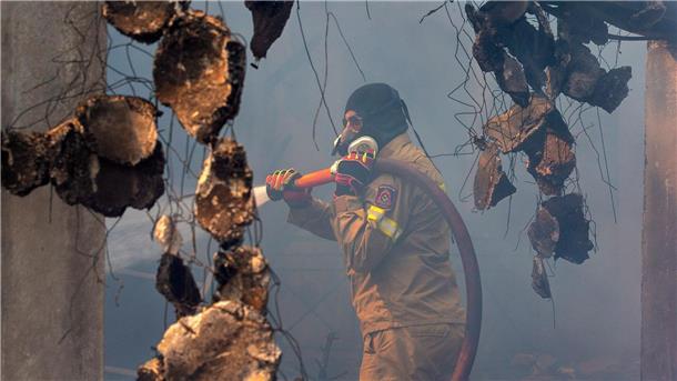 Brände in Griechenland „größte in der Geschichte der EU“ Ein Feuerwehrmann bekämpft einen Waldbrand in der Nähe von Athen.