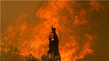 Ein Feuerwehrmann kämpft im griechischen Dorf Hasia nahe Athen gegen ein Flammenmeer.