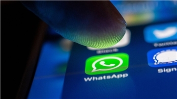 Ein Finger berührt das Whatsapp-Logo auf einem Smartphone.