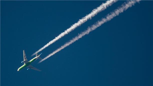 Ein Flugzeug hinterlässt Kondensstreifen am Himmel. Spätestens Mitte des Jahrhunderts soll schließlich mit grünem Wasserstoff geflogen werden.