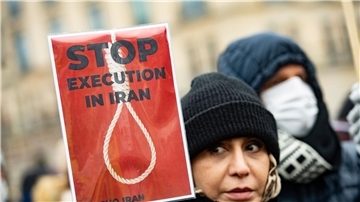 Ein Frau protestiert in Berlin gegen die Hinrichtungen im Iran.