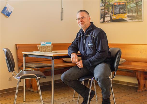 Feuerteufel, Baseballschläger und mehr: Ein Busabenteuer in Bremerhaven Busfahrer Pjer Ortmann im Pausenraum an der Haltestelle "Heinrich-Plett-Straße" in Leherheide: Er sitzt auf einem Stuhl an einem Tisch.