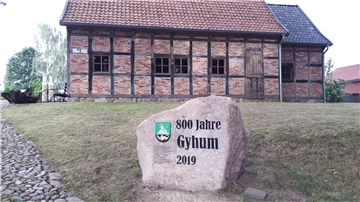 Ein Gedenkstein mit Wappen und Alter des Ortes erinnert an das Jubiläum in Gyhum.