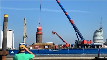 Ein Schaulustiger blickt auf den Leuchtturm der Nordmole.