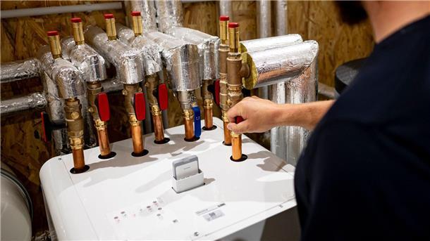 Wärmepumpe nach 10 bis 16 Jahren günstiger als Gasheizung Ein Handwerker arbeitet an einer Wärmepumpe in der Enpal Akademie.