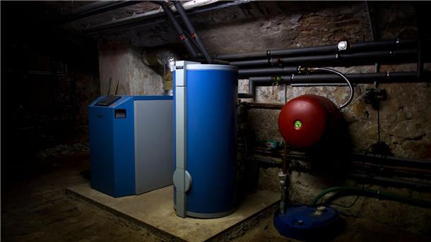 Ein Heizkessel und ein Warmwasserboiler stehen in einem Heizkeller in Dresden.