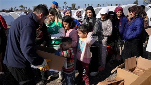 Ein Helfer verteilt in einem behelfsmäßigen Lager in Iskenderun Lebensmittel an Menschen, die bei den verheerenden Erdbeben ihr Zuhause verloren haben.