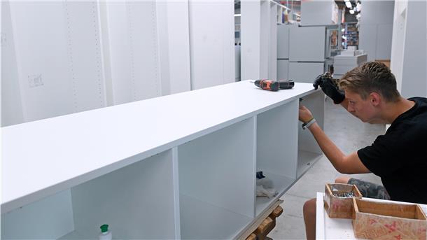 Darum kommt es zu Lieferengpässen in der Möbelbranche Ein Holzmechaniker montiert in einer Möbelbaufirma Schränke.