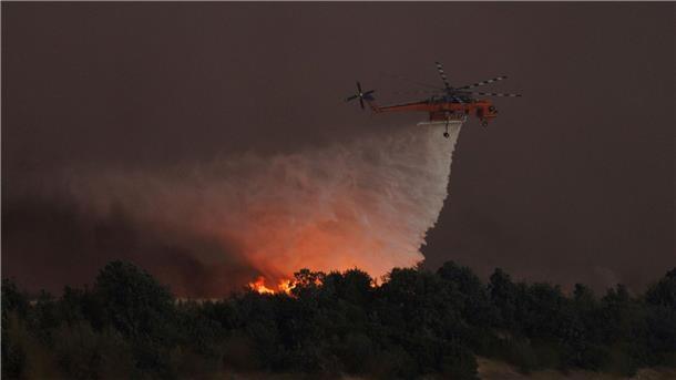 Griechenland kämpft gegen zahlreiche Brände Ein Hubschrauber wirft Wasser über dem Dorf Avantas ab. Stürmische Winde fachen die Flammen der Waldbrände in ganz Griechenland an.