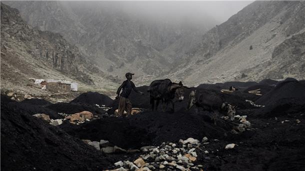 Verlorene Kindheit in Afghanistan Ein Junge führt einen mit Kohle beladenen Esel von einer informellen Kohlemine zu einer Sammelstelle am Fuße des Berges.