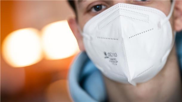 Ein junger Mann trägt eine FFP2-Maske. Sie bietet einen erhöhten Schutz vor den Coronaviren.