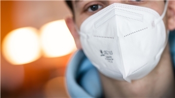 Ein junger Mann trägt eine FFP2-Maske. Sie bietet einen erhöhten Schutz vor den Coronaviren.