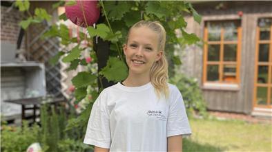Ein junges Mädchen lächelt in die Kamera. 