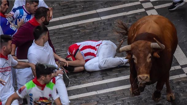 Ein Kampfstier läuft am dritten Tag des Stiertreibens während des „Sanfermines“-Fest zwischen den Menschen umher.