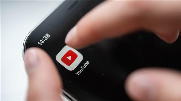 Kinder als Youtube-Stars: Wann treiben Eltern es zu weit? Ein Kind bedient ein Smartphone, auf dem eine Youtube-App zu sehen ist.