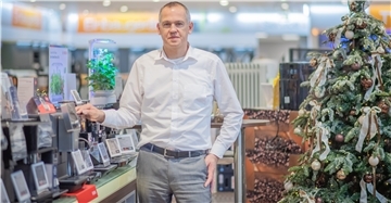 Ein Mann steht in einem Elektronik-Fachmarkt vor einem Regal mit Kaffeevollautomaten