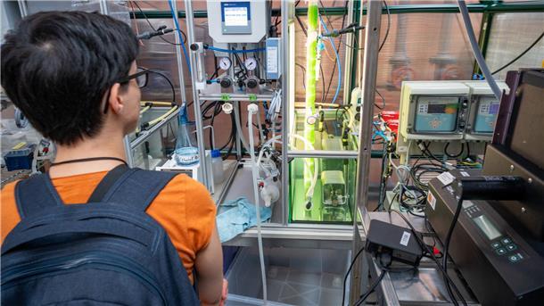 Studieninteressierte vor einem Bioreaktor mit Mikroalgen bei der Hochschule Bremerhaven.