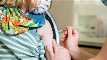 Ein kleines Mädchen wird gegen das Coronavirus geimpft.