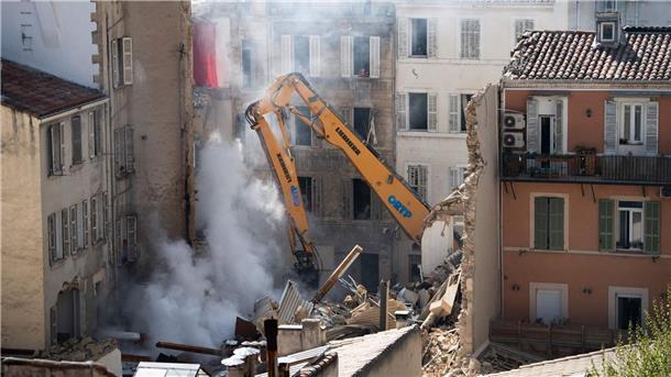Ein Kran bewegt Schutt eines eingestürzten Gebäudes in der Innenstadt von Marseille.