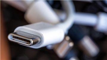 Ein Ladekabel mit USB-C-Stecker liegt neben einem Bündel unterschiedlicher Anschlusskabel.