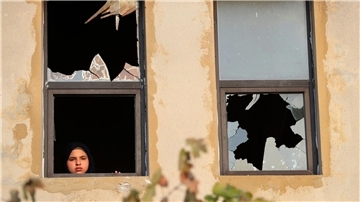 Ein libanesisches Mädchen blickt nach israelischem Beschuss auf ein Dorf im Südlibanon durch ein zerbrochenes Fenster.