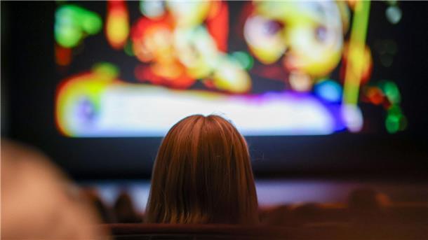 Ab ins Kino für fünf Euro Ein Mädchen schaut in einem Kino einen Film. Am Wochenende geht das in vielen Kinos in Deutschland für fünf Euro.