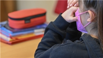Ein Mädchen trägt eine Maske im Unterricht in einer Grundschule.
