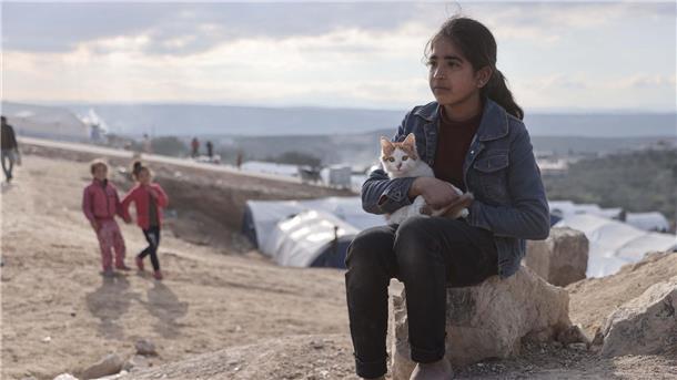 Ein Mädchen und ihre Katze in einem Notlager im syrischen Salqin.