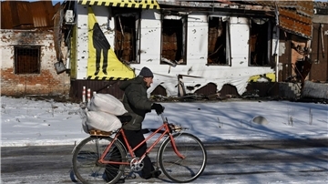 Ein Mann bringt im Gebiet Saporischschja Hilfsgüter mit seinem Fahrrad nach Hause.