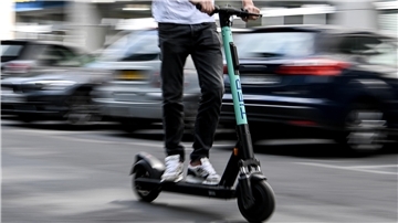 Ein Mann fährt mit einem E-Roller