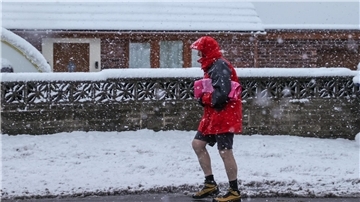 Ein Mann geht im nordenglischen  Barnsley bei starkem Schneefall in seinen Shorts spazieren.