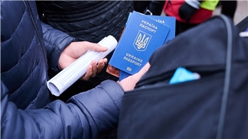 Ein Mann hält ukrainische Pässe.