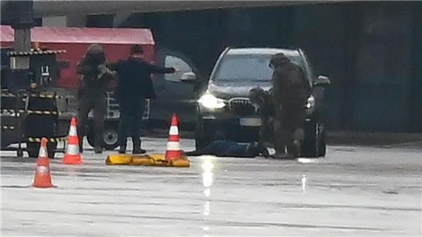 Ein Mann liegt am Hamburger Flughafen umringt von Polizeikräften auf dem Boden.