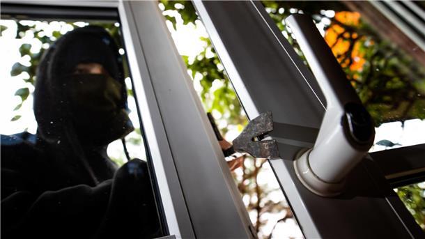 Einbruchszahlen in Bremerhaven steigen: Welche Rolle spielen Intensivtäter? Ein Mann mimt einen Einbrecher und benutzt ein Brecheisen, um eine gekippte Terrassentür aufzuhebeln.