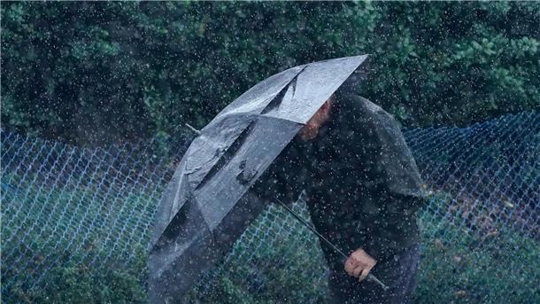 Tornados und Todesopfer nach Überschwemmungen in den USA Ein Mann schützt sich in San Francisco vor Wind und Regen.