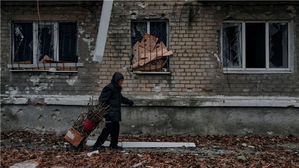 Krieg gegen die Ukraine: So ist die Lage Ein Mann trägt Reisig für einen Holzofen zum Keller eines Wohnhauses im Osten der Ukraine.