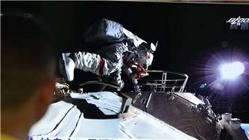 Ein Mann verfolgt vor dem Fernseher die Live-Übertragung eines Außeneinsatzes an der Raumstation „Tiangong“ (Archivbild).