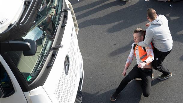 Autofahrer attackieren Klimaktivisten in Berlin Ein Mann zerrt einen Aktivisten der Gruppe Letzte Generation während einer Blockade auf der Stadtautobahn A100 in Berlin von der Straße.