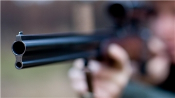 Ein Mann zielt mit einem Jagdgewehr.