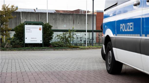 Ein Mannschaftswagen steht vor der JVA. 
