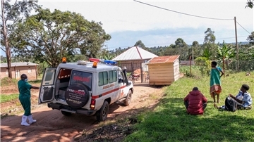 Ein medizinischer Mitarbeiter der Uganda Red Cross Society fordert Menschen mit Verdacht auf eine Ebola-Erkrankung dazu auf, in einen Krankenwagen einzusteigen.